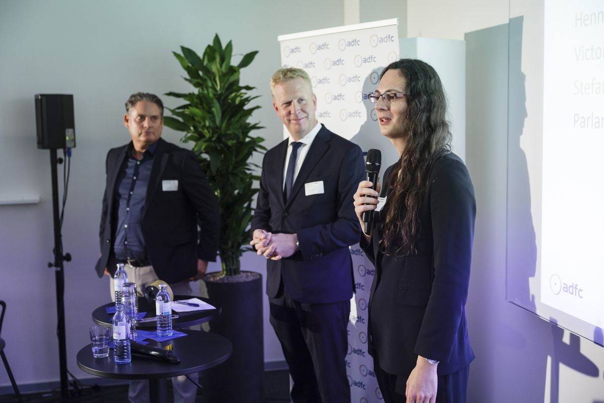 Parlamentskreis Fahrrad Stefan Zierke MdB, Henning Rehbaum (MdB) und Victoria Broßart MdB von Parlamentskreis Fahrrad stehen auf der Bühne, Broßart mit Mikrofon in der Hand.